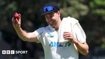 Jacob Duffy holds up a cricket ball
