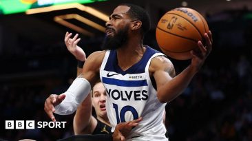 Mike Conley holds a basketball in his hand