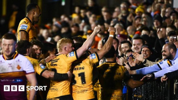 Castleford players come together with try scorer Tom Weaver to celebrate with fans behind the in-goal area