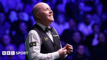 John Higgins looks up and smiles
