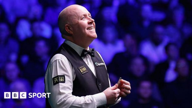 John Higgins looks up and smiles