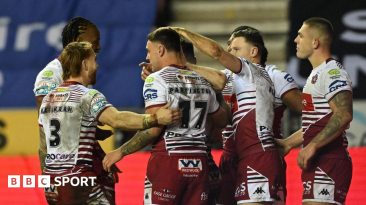 Wigan players congratulate number 17 Oli Partington on scoring a try against Leigh Leopards