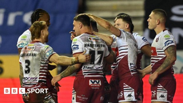 Wigan players congratulate number 17 Oli Partington on scoring a try against Leigh Leopards