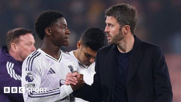 Manchester United head coach Michael Carrick (right) shakes hands with Kobbie Mainoo
