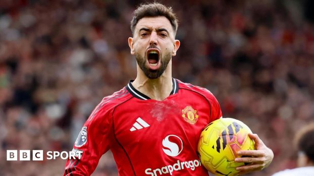 Bruno Fernandes celebrates a goal for Manchester United, with his mouth wide open and the ball in his left hand