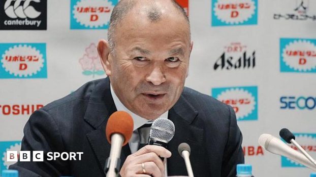 Eddie Jones speaks into a microphone