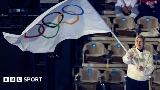 IOC president Kirsty Coventry waving an Olympic flag