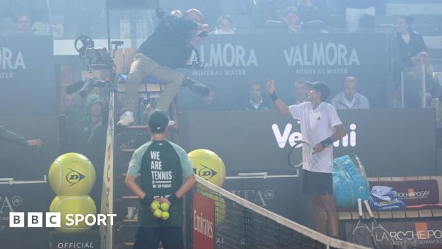 Spain's Rafael Jodar speaks with umpire Manuel Messina after smoke from the Coppa Italia final between Inter Milan and Lazio surrounds the court in his Italian Open quarter-final against Italy's Luciano Darderi