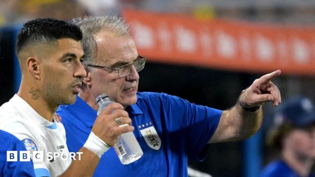 Marcelo Bielsa pointing while standing on the sidelines with Luis Suarez